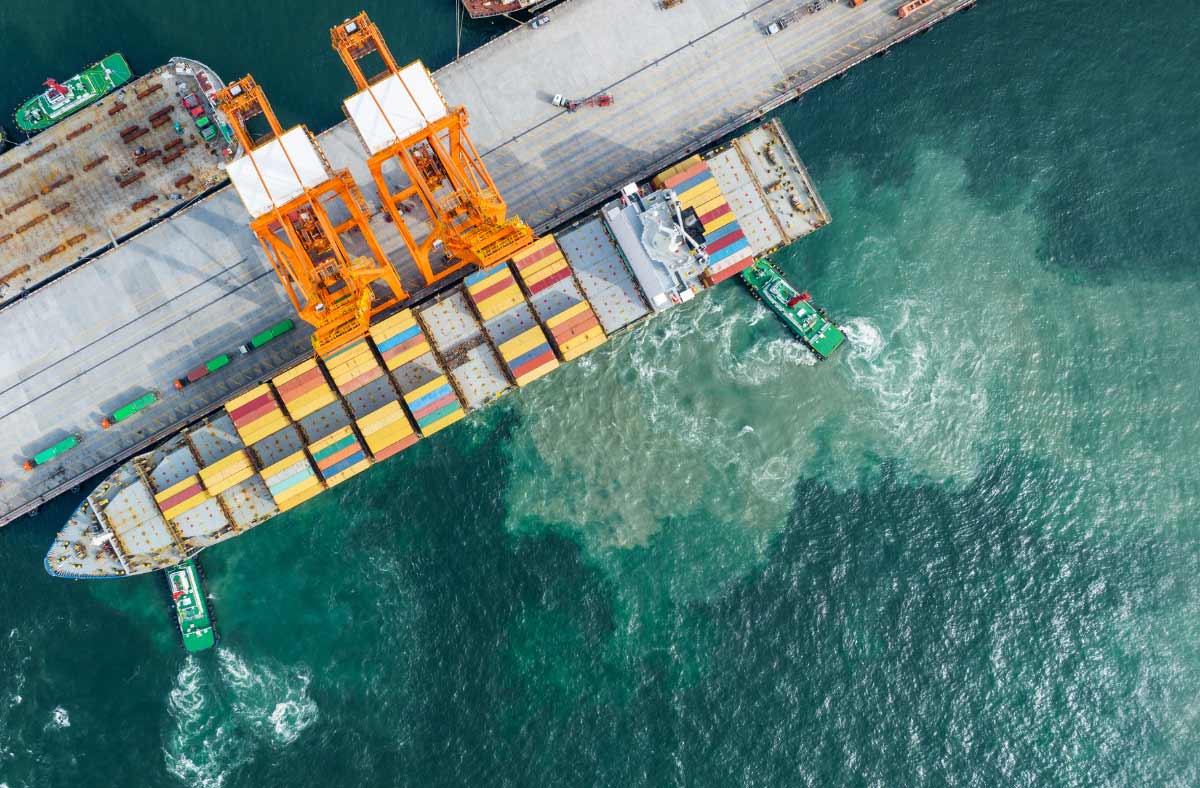 cargo ship docked at a port being unloaded as part of the customs processes