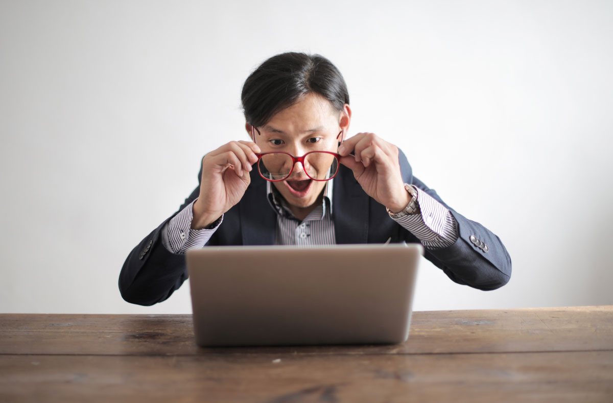 business man looking amazed at laptop screen