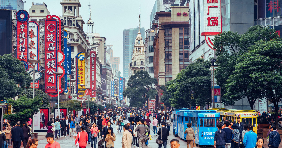 Busy Shanghai shopping area streetscape with people, shops, signs, streetcars, demonstrating the possibilities for Chinese market entry